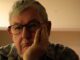 Pensive older man with glasses resting chin