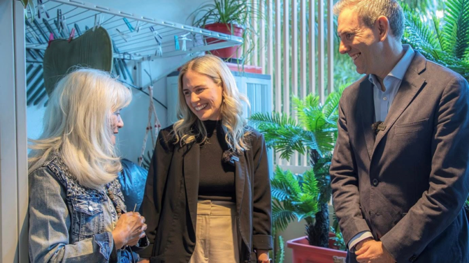 Three people smiling amid indoor plants