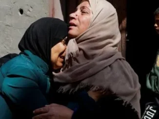 Two women embracing in grief, boy nearby