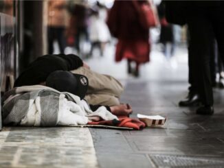 Homeless person sleeping on city sidewalk