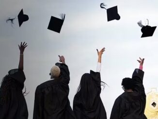 Graduates throwing graduation caps into the sky