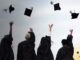 Graduates throwing graduation caps into the sky