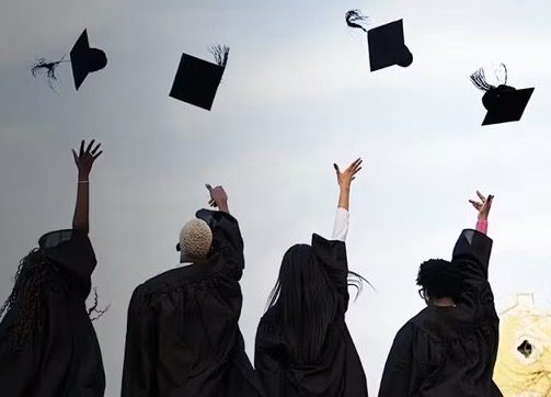 Graduates throwing graduation caps into the sky