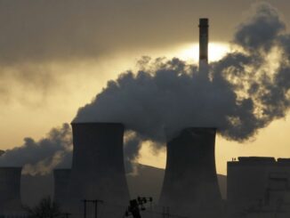 Power plant cooling towers emitting steam at sunset