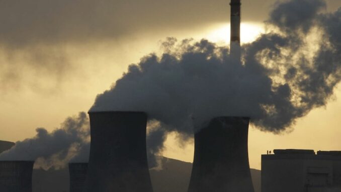 Power plant cooling towers emitting steam at sunset Power plant cooling towers emitting steam at sunset