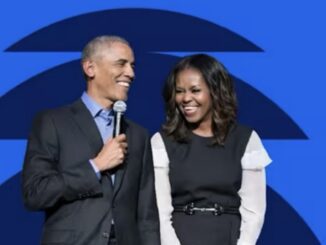 Smiling man and woman on stage with microphone