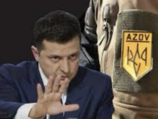Man gesturing beside soldier's arm patch