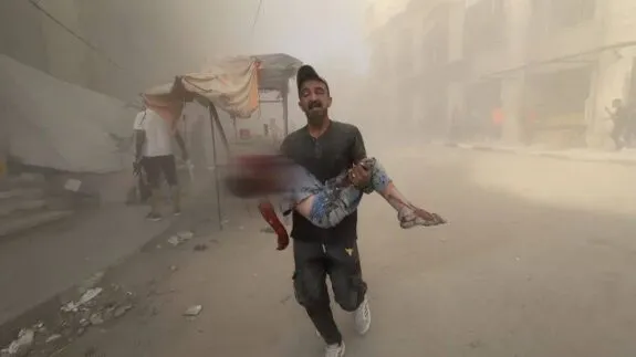 Man carrying child through dusty, rubble-strewn street Man carrying child through dusty, rubble-strewn street
