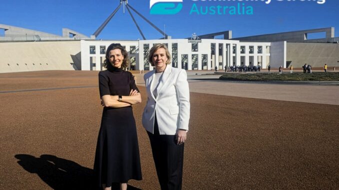 Two women outside Australian Parliament House, logo
