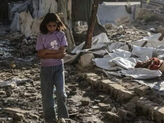 Girl walking through rubble in makeshift camp