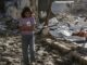 Girl walking through rubble in makeshift camp