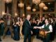 Formal ballroom handshake amid dancing crowd
