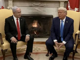 Two men in suits seated by fireplace