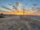Sunset over rural field with wire fence