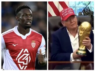 Soccer player in red jersey; man holding trophy