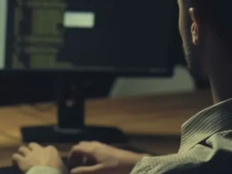 Person typing at computer monitor