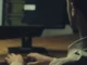 Person typing at computer monitor