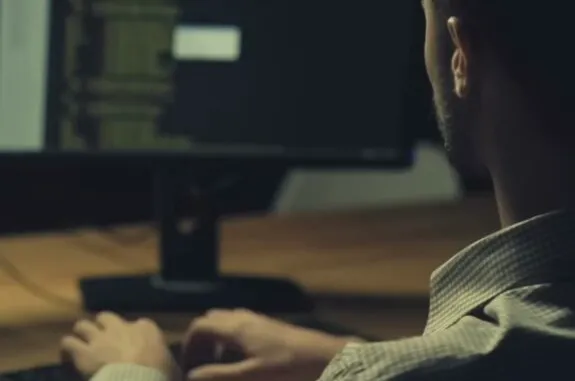 Person typing at computer monitor