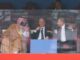 Three men laughing in stadium VIP box
