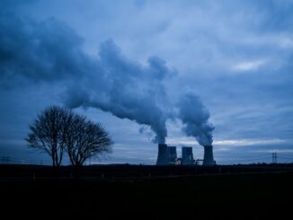 Power plant cooling towers emitting steam at dusk