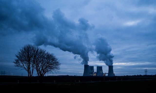 Power plant cooling towers emitting steam at dusk
