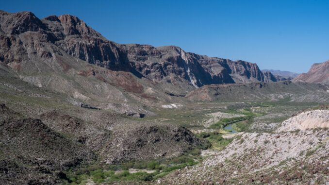 Arid canyon valley with river and cliffs Arid canyon valley with river and cliffs